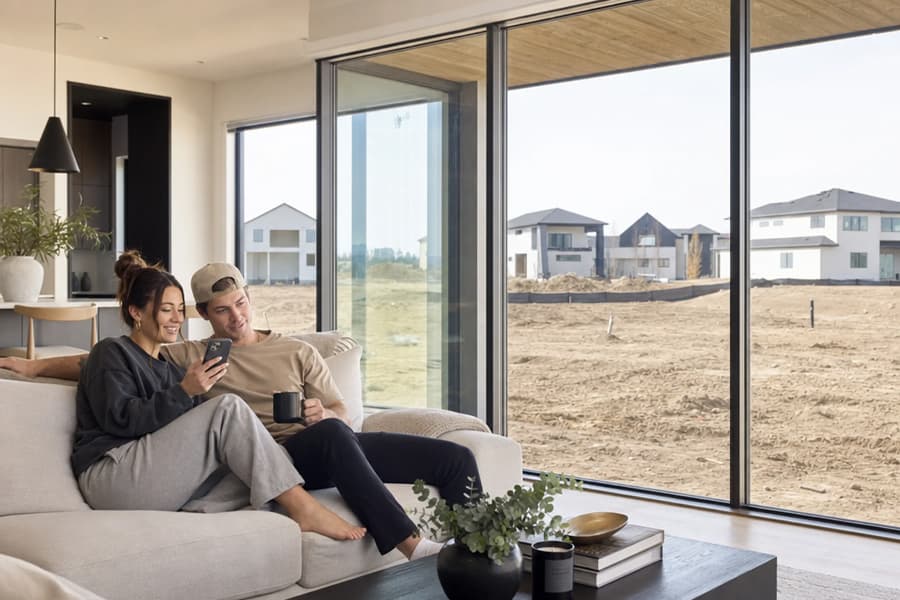 Homeowners sitting together looking out over the raw graded ground of their property